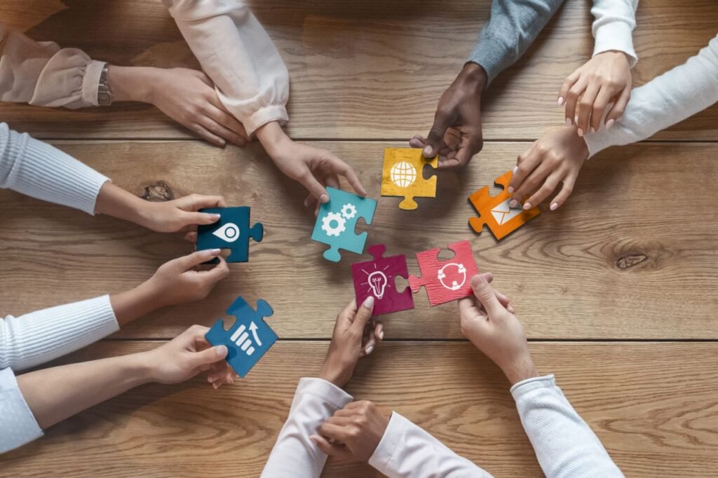 Groupes de personnes qui assemblent un puzzle ensemble pour symboliser le travail d'équipe